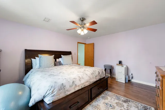 a bedroom with a bed a large window and chair