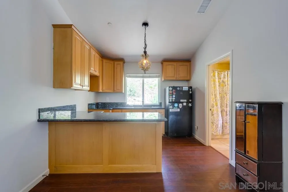 460 Pile Street Ramona, CA 92065 - Photo 16 of 25 a kitchen with stainless steel appliances granite countertop a refrigerator a sink dishwasher a stove and white countertops with wooden floor