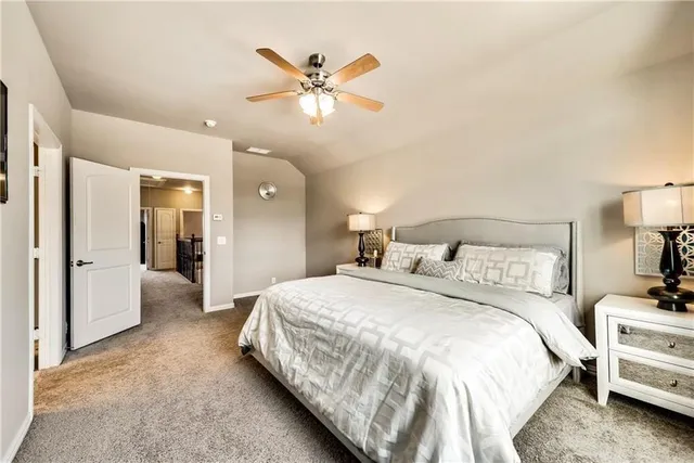 a spacious bedroom with a bed and a lamp