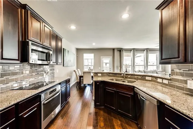 a kitchen with stainless steel appliances granite countertop a sink stove and oven
