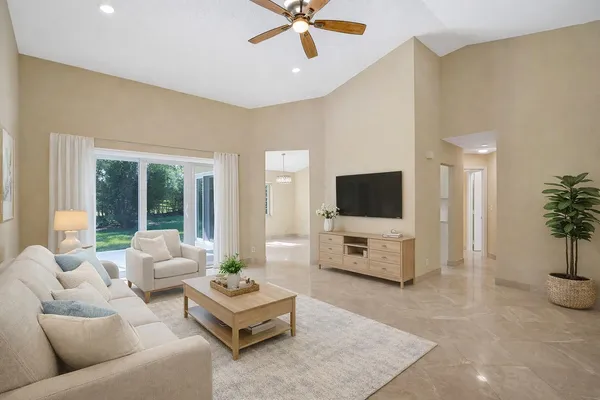 a view of an empty room with window and a ceiling fan