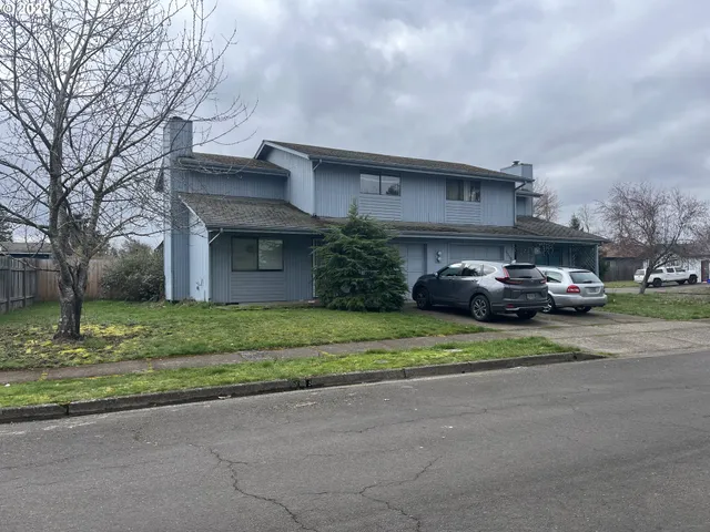 a front view of a house with a garden and parking
