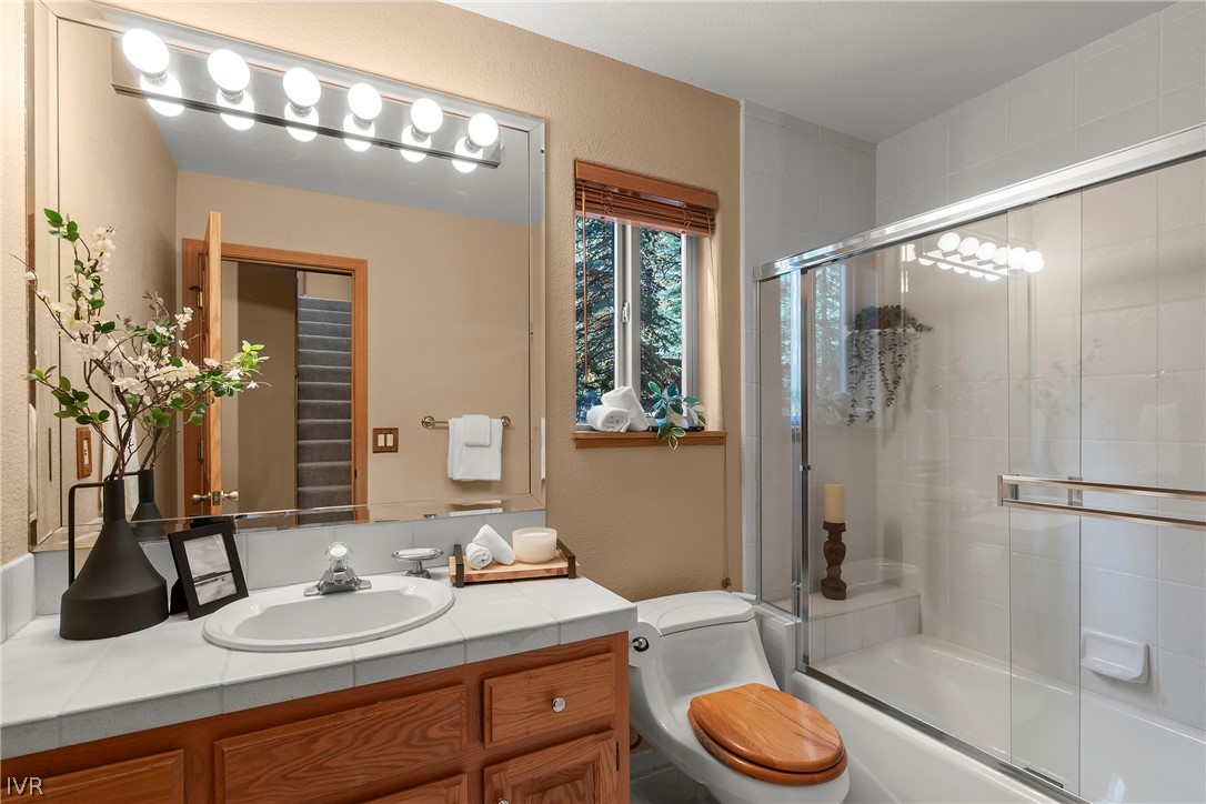 858 Jennifer Street Incline Village, NV 89451 - Photo 26 of 44 a bathroom with a granite countertop sink toilet a mirror and shower