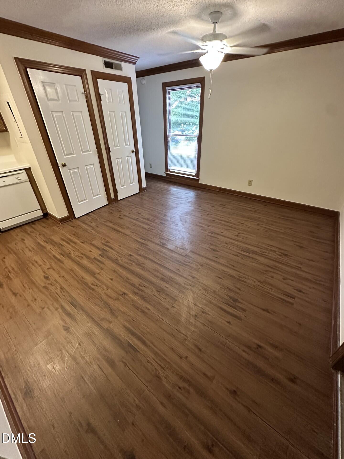 a view of empty room with window and wooden floor