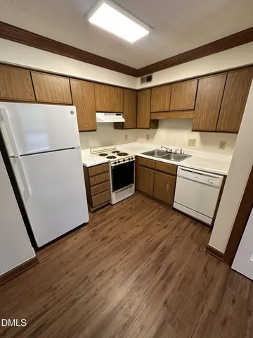 a kitchen with stainless steel appliances granite countertop a refrigerator a stove a sink and white cabinets