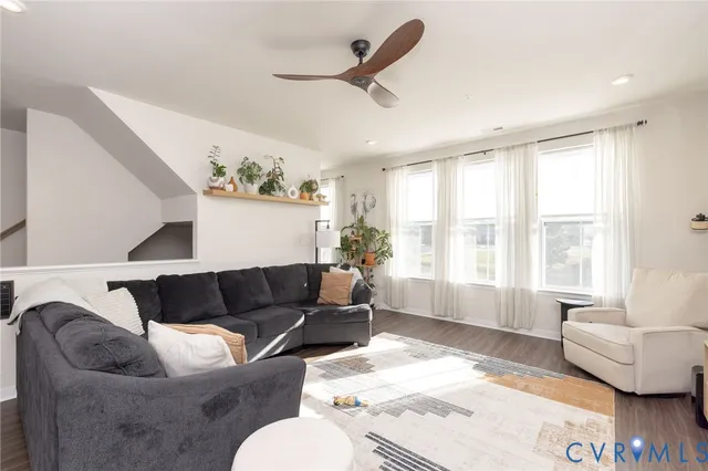 a living room with furniture and a dining table with wooden floor