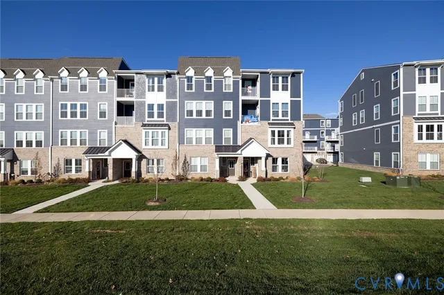 a front view of a residential apartment building with a yard