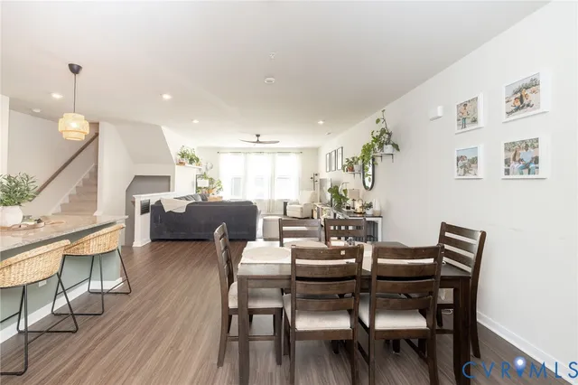 a kitchen with stainless steel appliances granite countertop a sink a stove a refrigerator and island with wooden floor