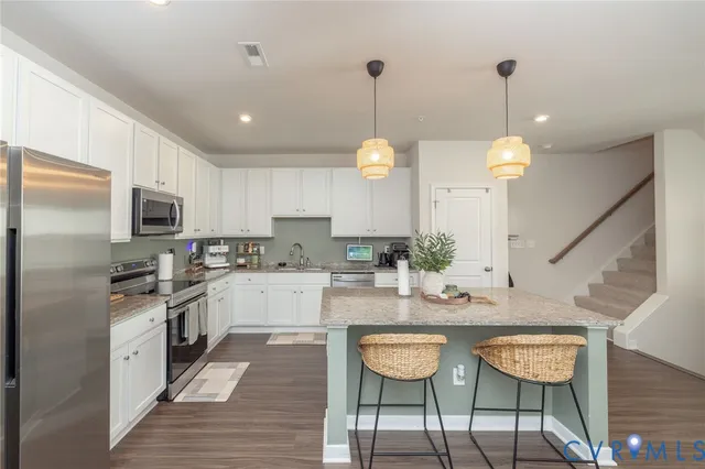 a kitchen with kitchen island granite countertop wooden cabinets and white appliances