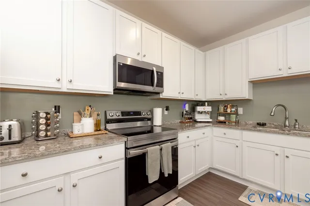 a kitchen with stainless steel appliances granite countertop a sink and a microwave