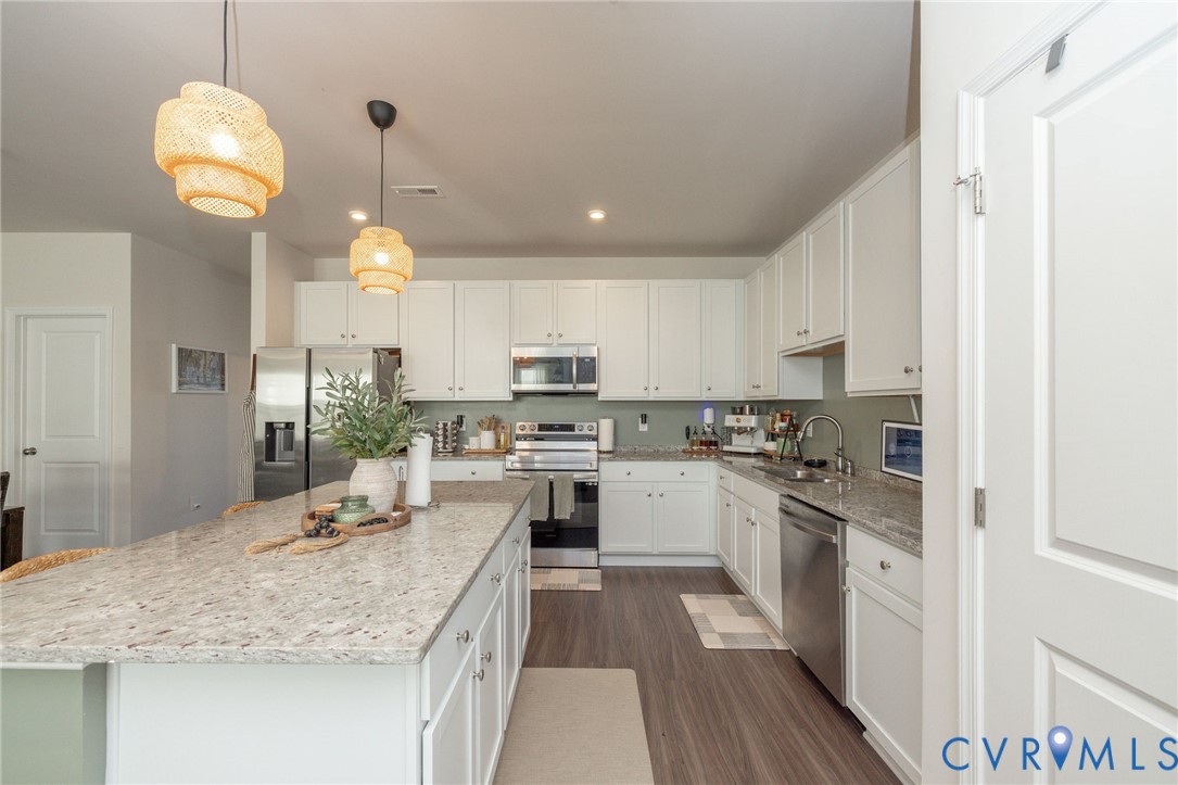 14435 Hancock Towns Drive Chesterfield, VA 23832 - Photo 9 of 34 a kitchen with kitchen island granite countertop wooden cabinets and white appliances