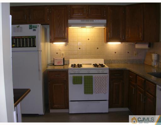 112 Woodbury Road Edison, NJ 08820 - Photo 3 of 6 a kitchen with a stove and a refrigerator