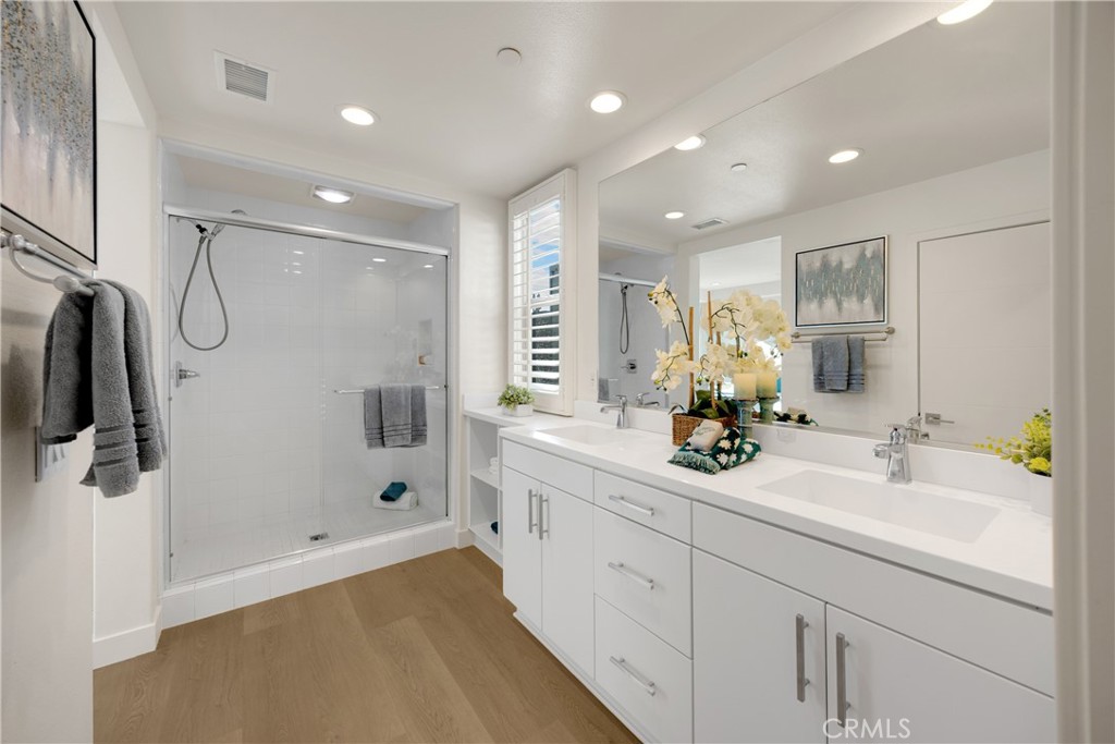 269 Magnet Irvine, CA 92618 - Photo 29 of 61 a bathroom with a double vanity sink a mirror a shower and a bathtub