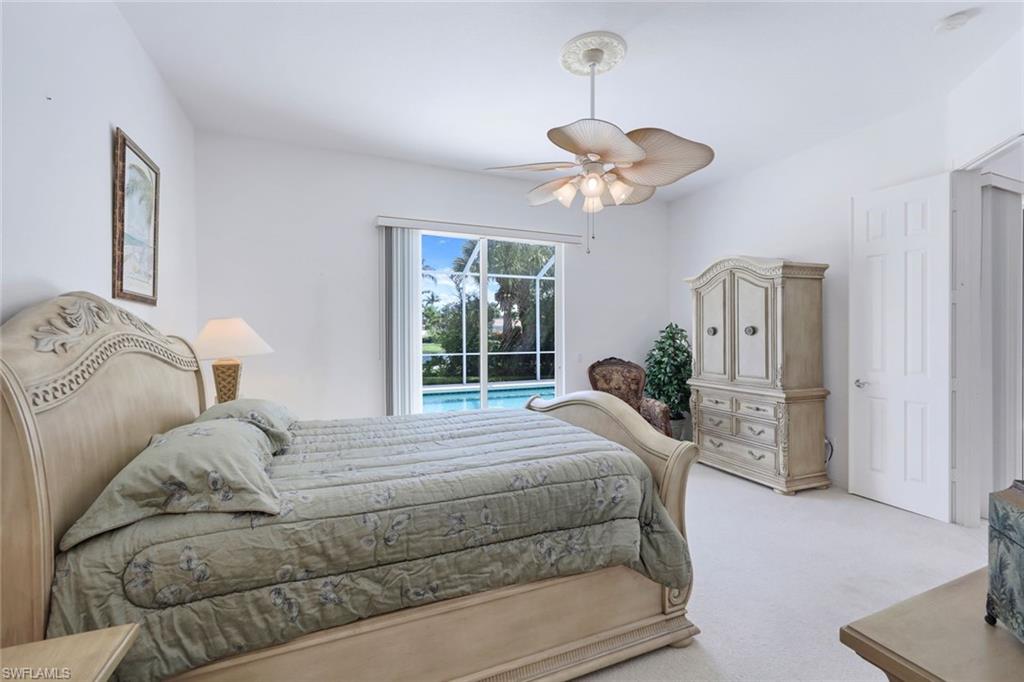 3059 Ellice Way Naples, FL 34119 - Photo 14 of 50 a bedroom with a large bed and a chandelier