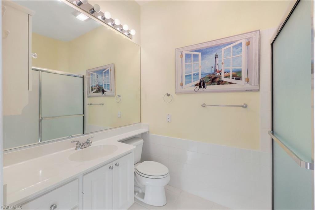 3059 Ellice Way Naples, FL 34119 - Photo 17 of 50 a bathroom with a sink a toilet and mirror