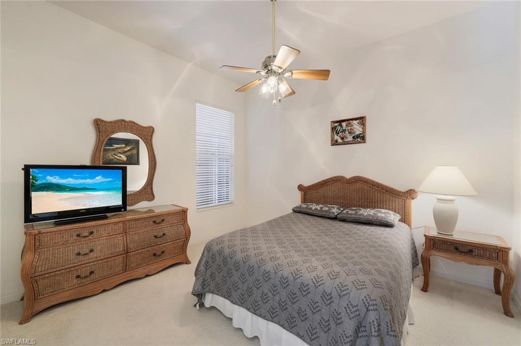 3059 Ellice Way Naples, FL 34119 - Photo 21 of 50 a bedroom with a bed and a flat screen tv