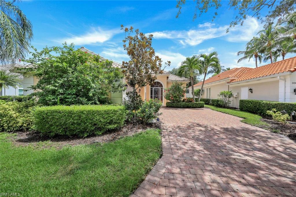 3059 Ellice Way Naples, FL 34119 - Photo 28 of 50 a front view of a house with a yard and potted plants