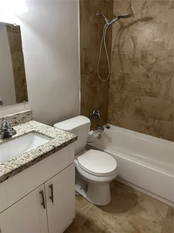 a bathroom with a granite countertop sink toilet and a mirror
