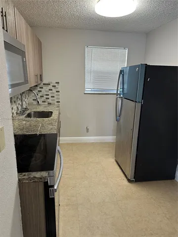 a kitchen with a refrigerator and a stove