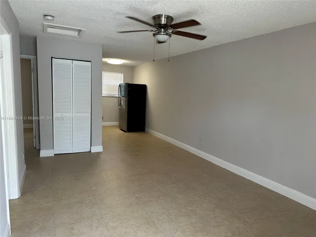 a view of a livingroom with a ceiling fan a ceiling fan and refrigerator