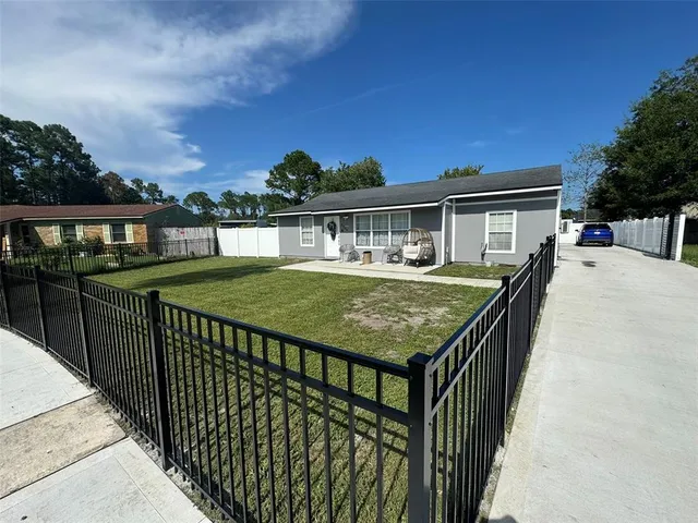 a view of a house with backyard and deck