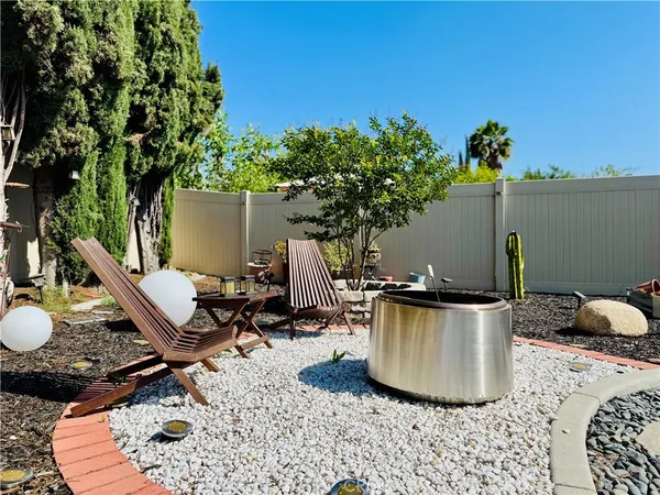 a view of a backyard with plants and outdoor seating