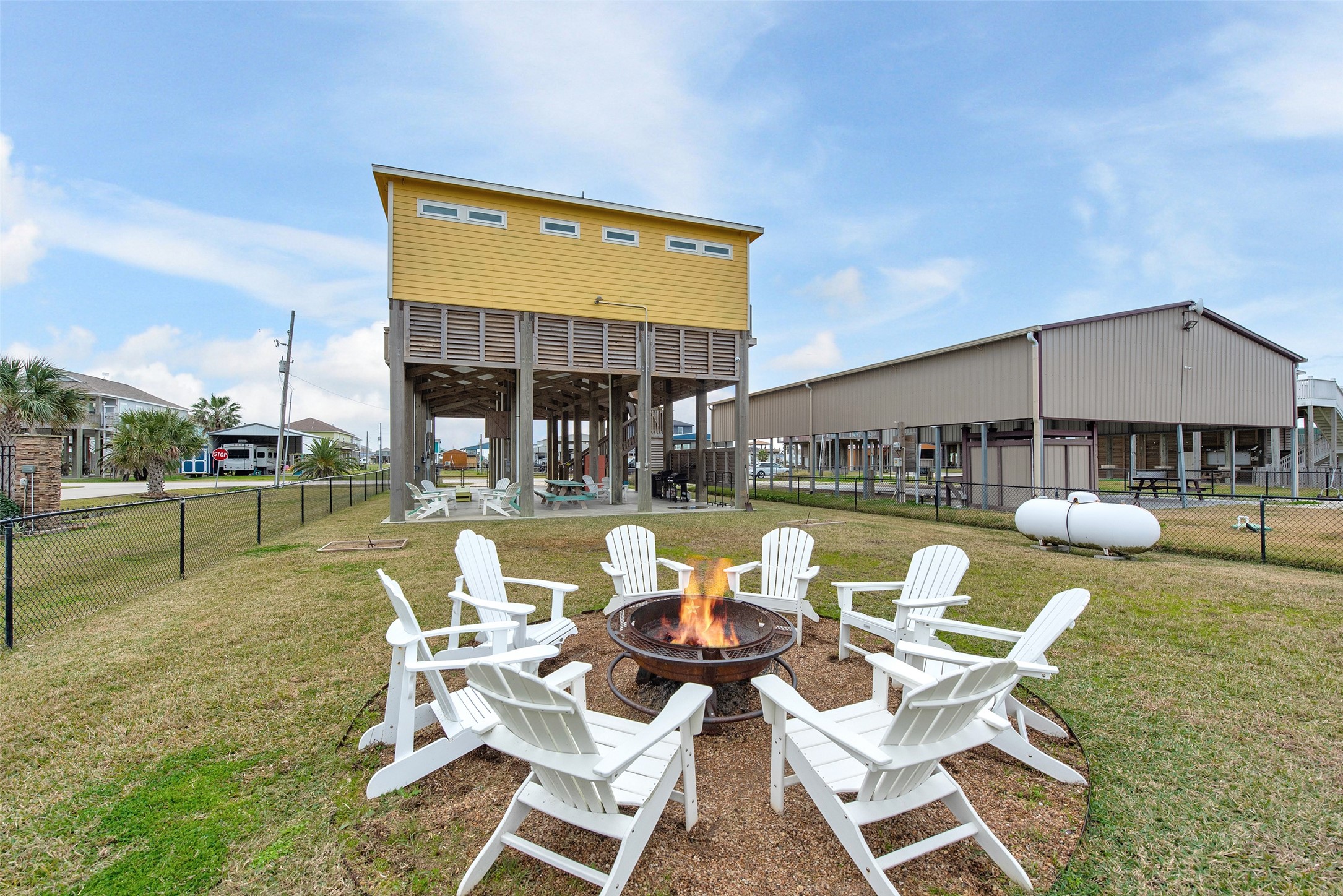 858 South East Road Crystal Beach, TX 77650 - Photo 11 of 44 a view of a house with patio outdoor dining table and chairs under an umbrella