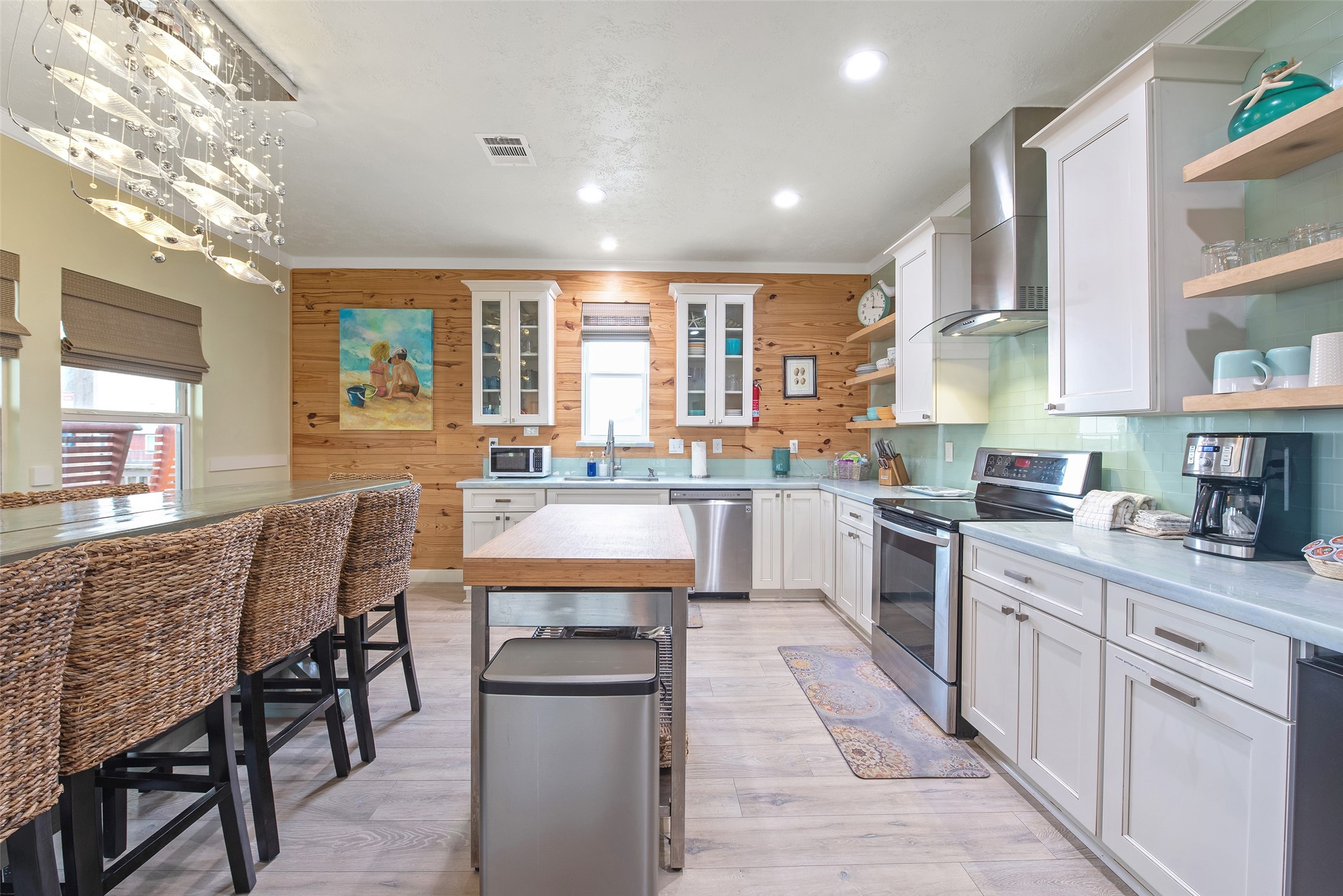 858 South East Road Crystal Beach, TX 77650 - Photo 27 of 44 a kitchen with stainless steel appliances kitchen island granite countertop a table chairs sink and cabinets