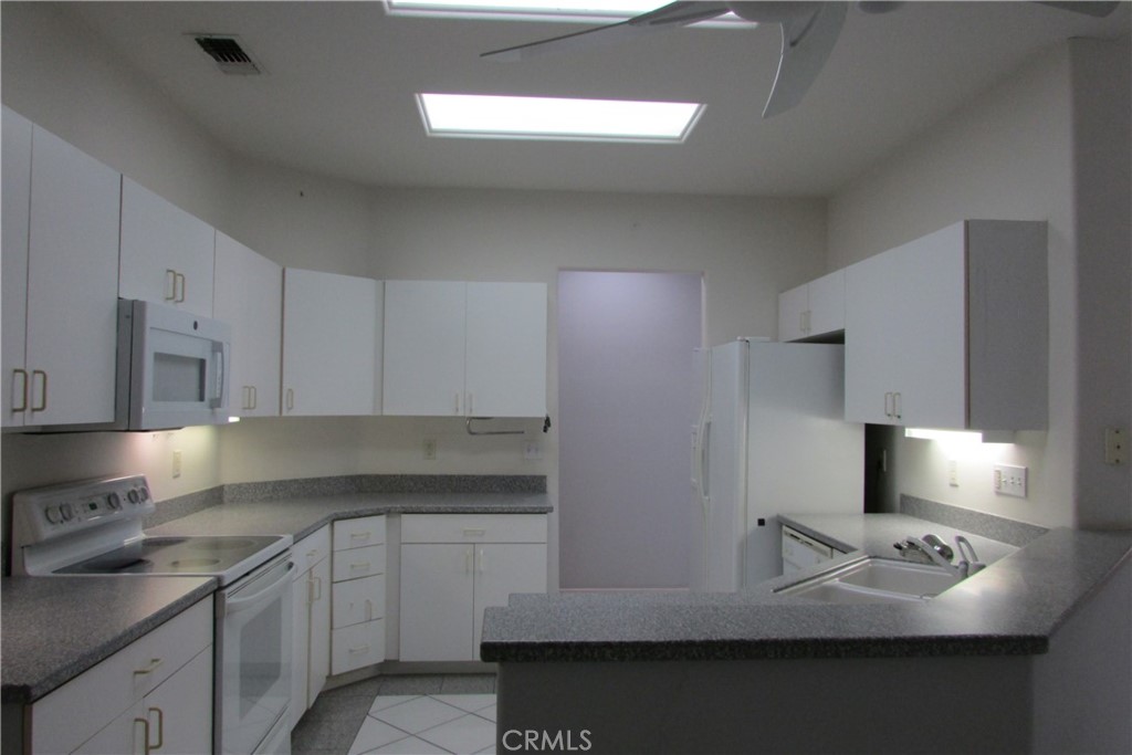 78281 Bovee Circle Palm Desert, CA 92211 - Photo 11 of 38 a kitchen with stainless steel appliances a sink stove and refrigerator