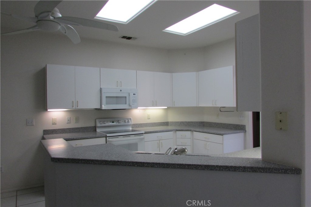 78281 Bovee Circle Palm Desert, CA 92211 - Photo 12 of 38 a kitchen with granite countertop a sink and cabinets