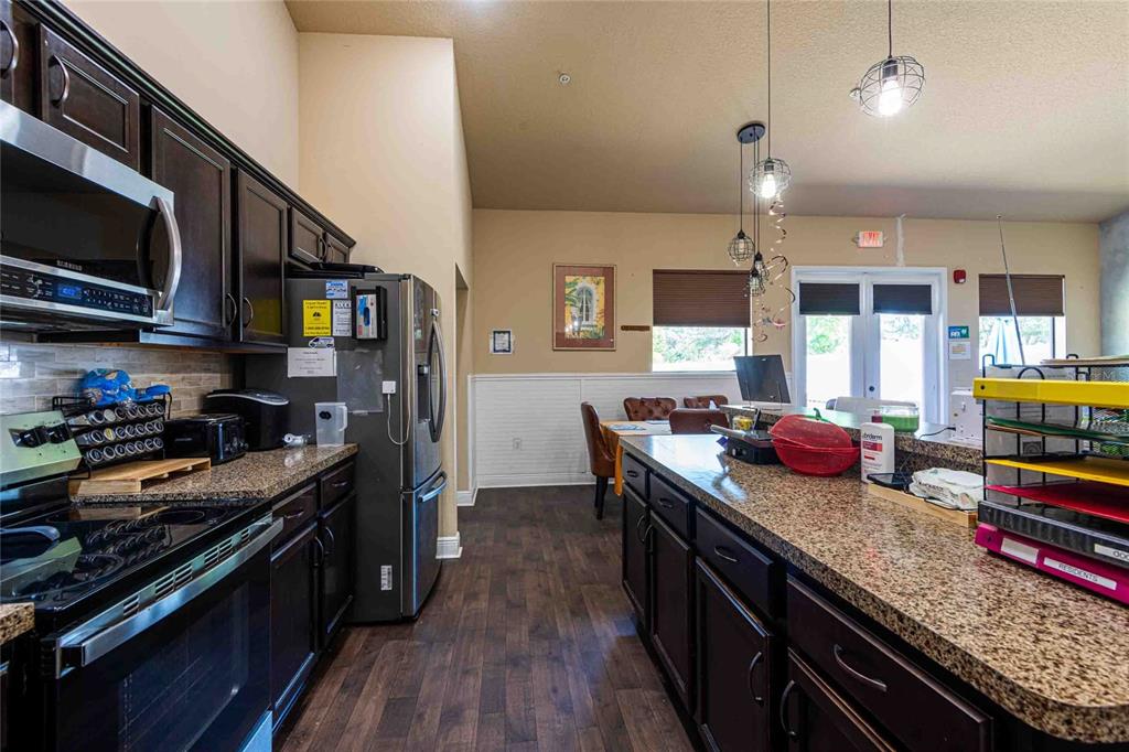 Undisclosed Address Spring Hill, FL 34608 - Photo 12 of 39 a kitchen with stainless steel appliances granite countertop a stove and a wooden floors
