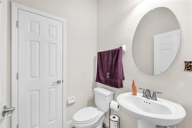 a bathroom with a toilet a sink and mirror