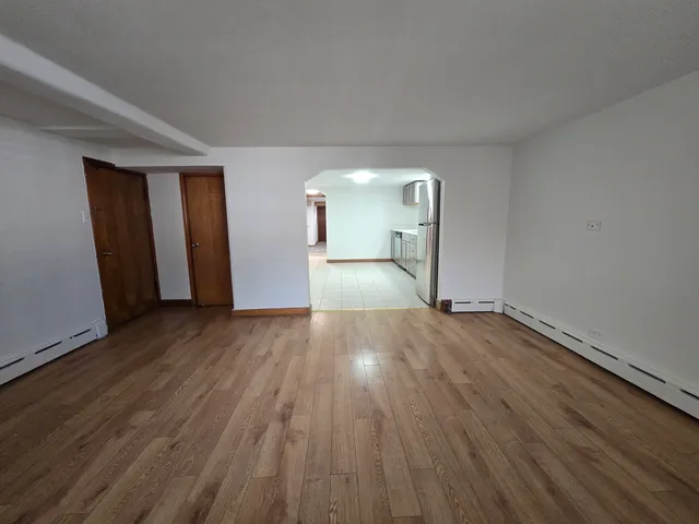 a view of empty room with wooden floor