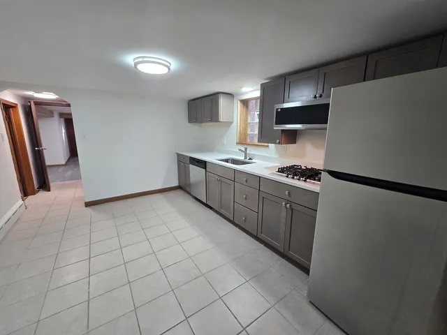 a kitchen with stainless steel appliances a refrigerator sink and microwave