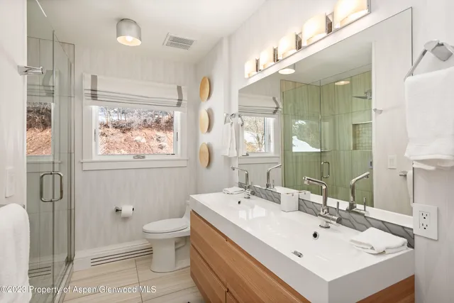 a spacious bathroom with a double vanity sink mirror and bathtub