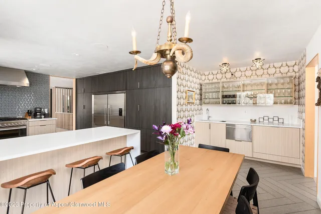 a kitchen with a dining table chairs stainless steel appliances and cabinets