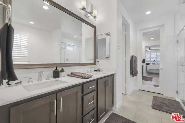 a bathroom with double sink and a mirror