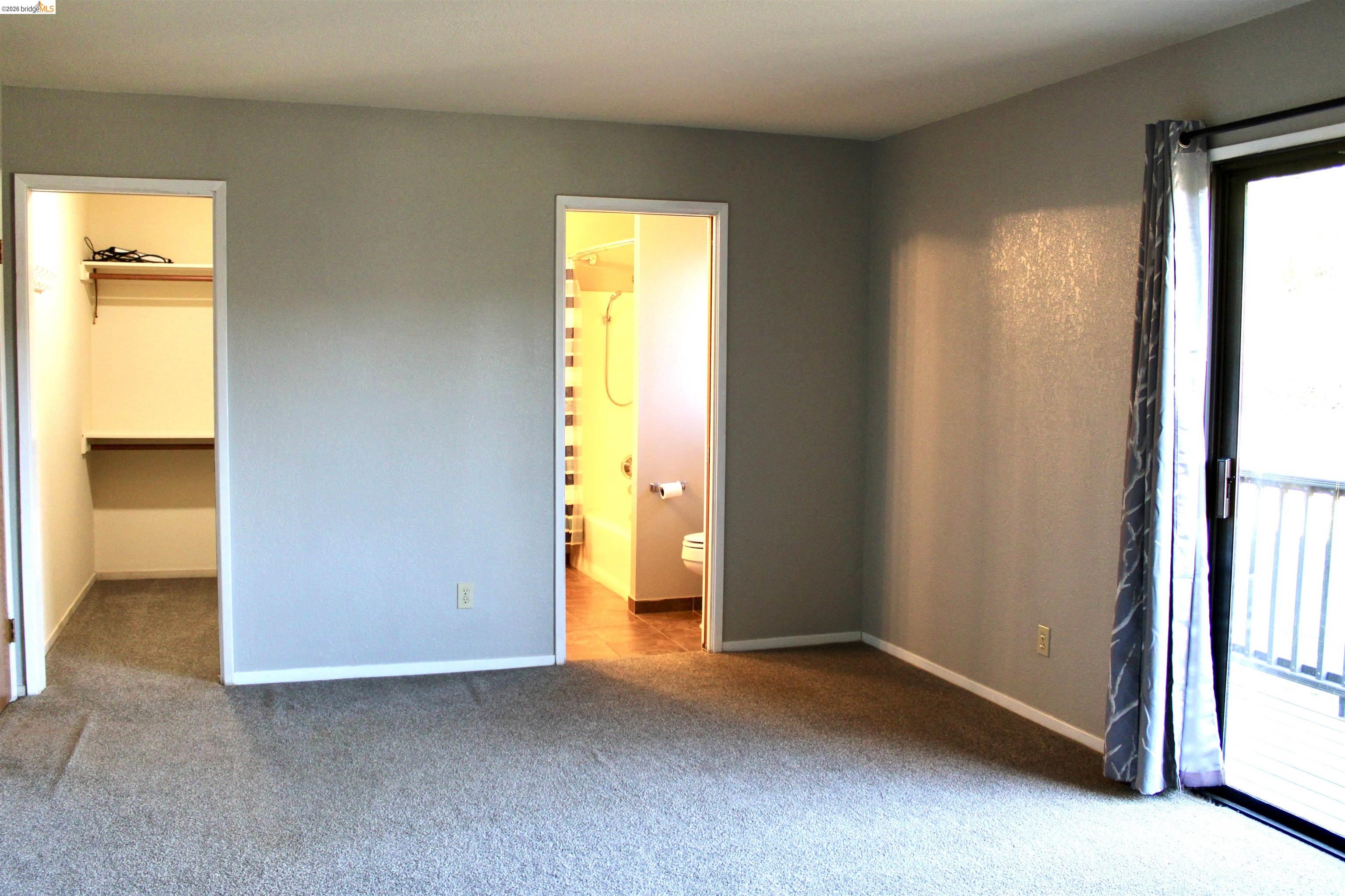 13033 Clements Road Groveland, CA 95321 - Photo 14 of 23 Unfurnished bedroom with a walk in closet, carpet, access to exterior, and connected bathroom