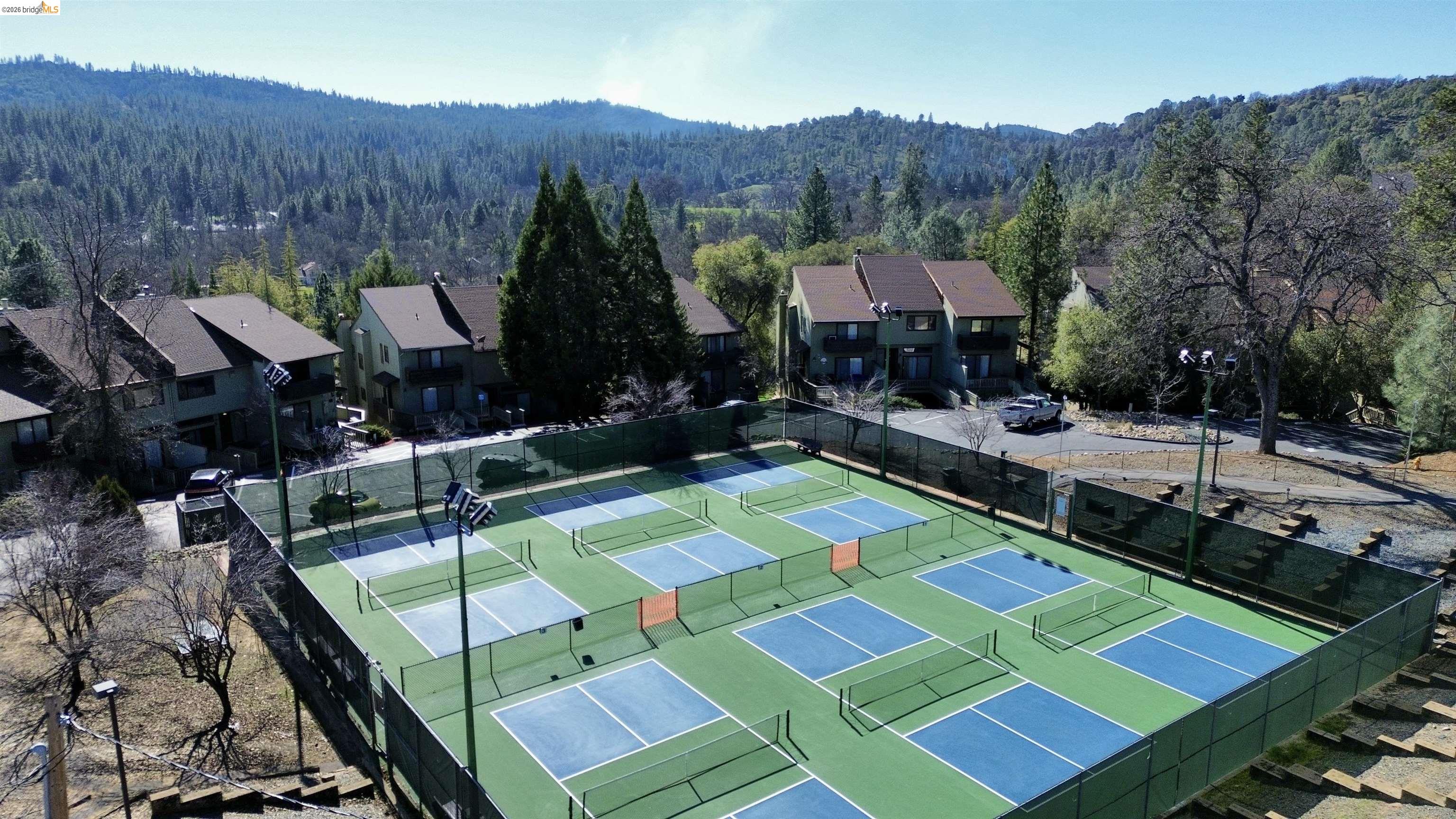 13033 Clements Road Groveland, CA 95321 - Photo 22 of 23 View of tennis court with a wooded view, a mountain view, and a residential view