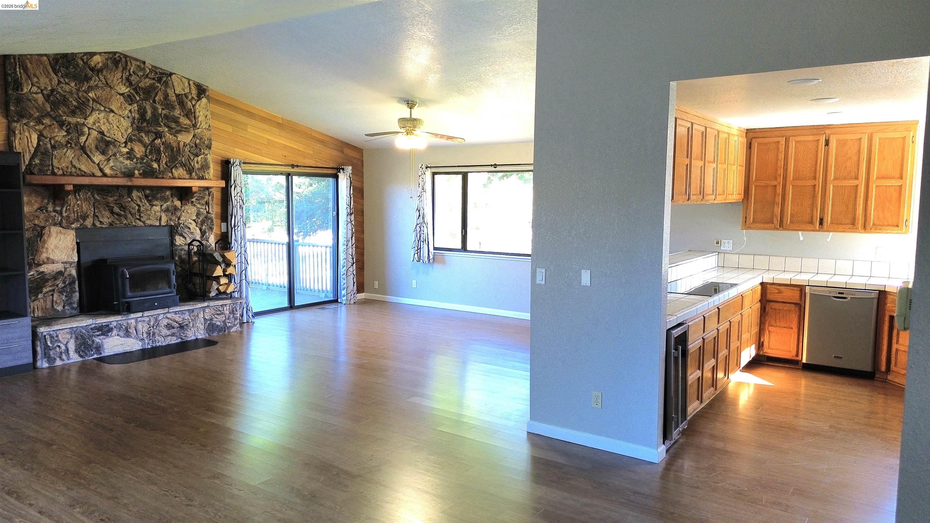 13033 Clements Road Groveland, CA 95321 - Photo 23 of 23 Kitchen featuring tile countertops, wood finish cabinets, open floor plan, dishwasher, and lofted ceiling