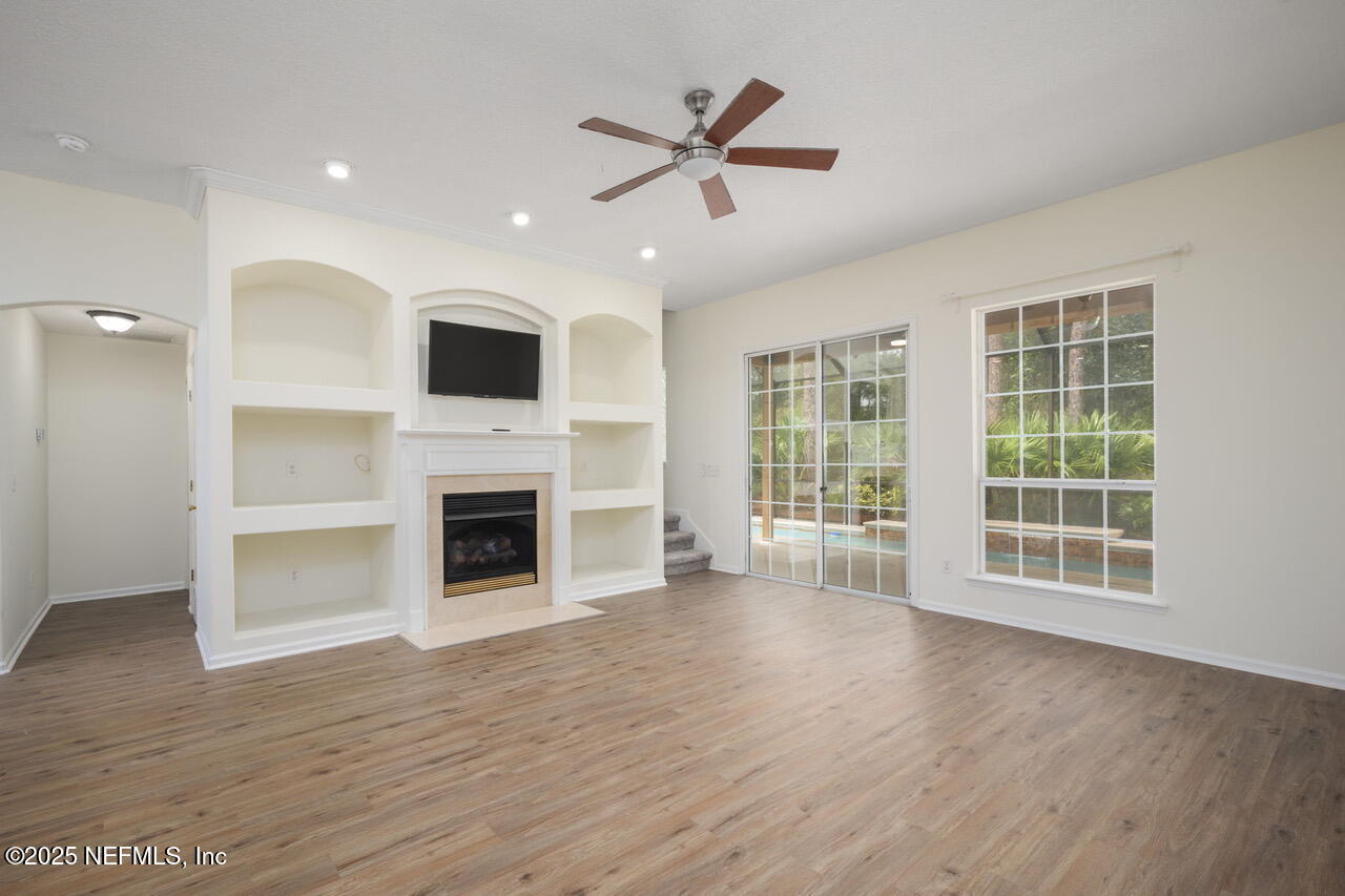 1140 Eddystone Lane Ponte Vedra, FL 32081 - Photo 11 of 29 a view of a livingroom with a fireplace a ceiling fan and wooden floor
