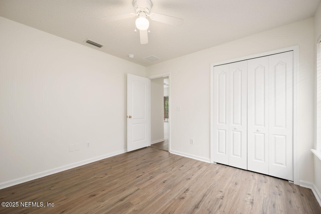 1140 Eddystone Lane Ponte Vedra, FL 32081 - Photo 23 of 29 an empty room with wooden floor chandelier fan and windows