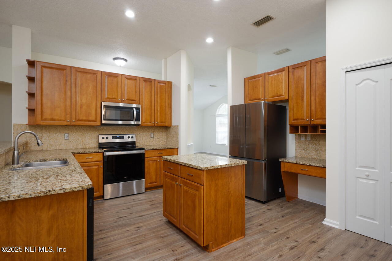 1140 Eddystone Lane Ponte Vedra, FL 32081 - Photo 8 of 29 a kitchen with stainless steel appliances granite countertop a refrigerator stove microwave and sink