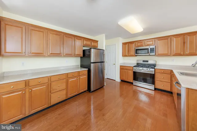 a kitchen with stainless steel appliances granite countertop a stove a sink dishwasher and a refrigerator