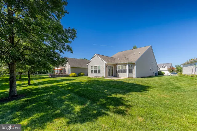 a view of a house with a big yard plants and large trees