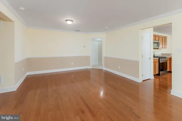 a view of empty room with wooden floor and fireplace