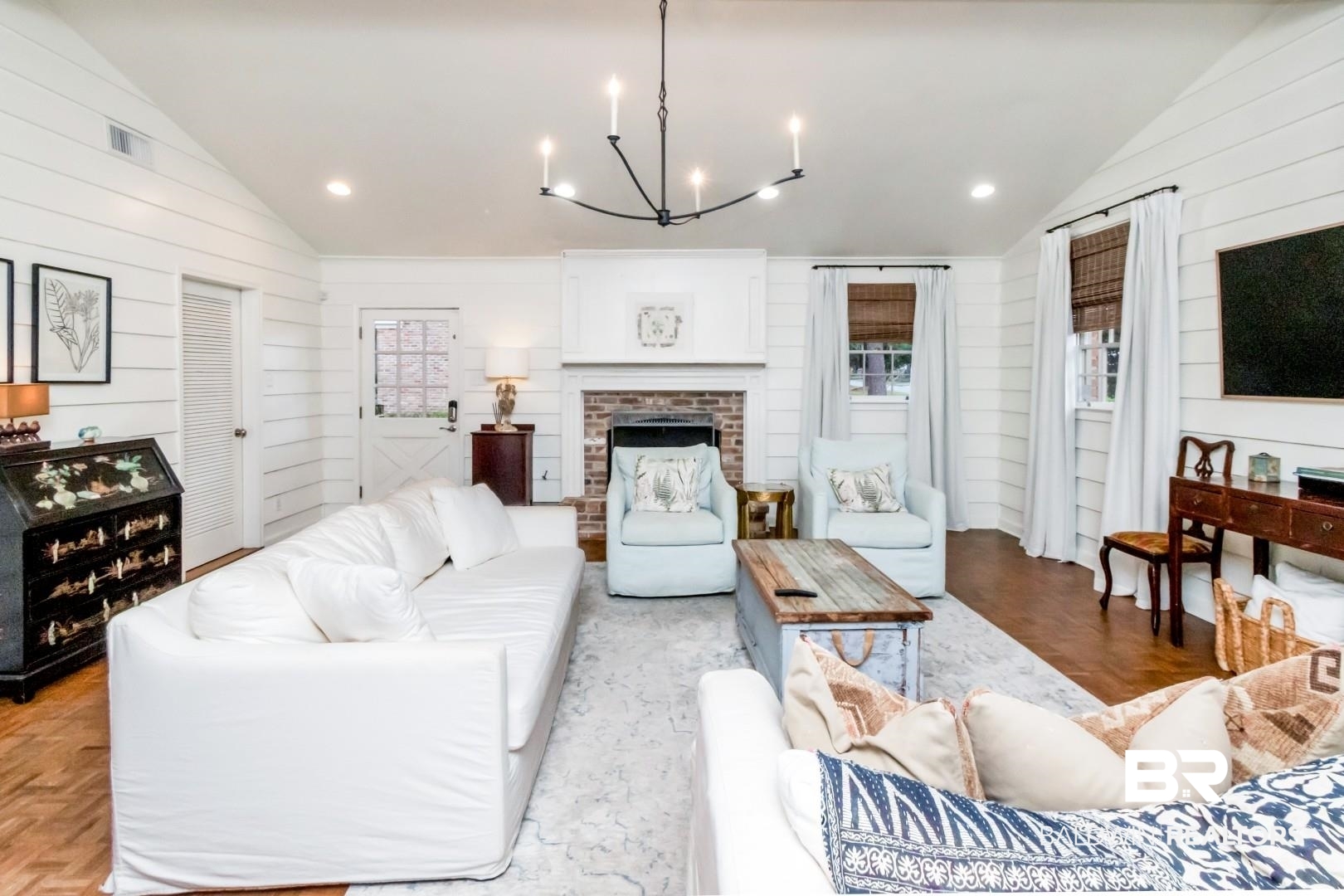 154 Fenwick Road Mobile, AL 36608 - Photo 5 of 48 Living area featuring a brick fireplace, lofted ceiling, parquet floors, wood walls, and a chandelier