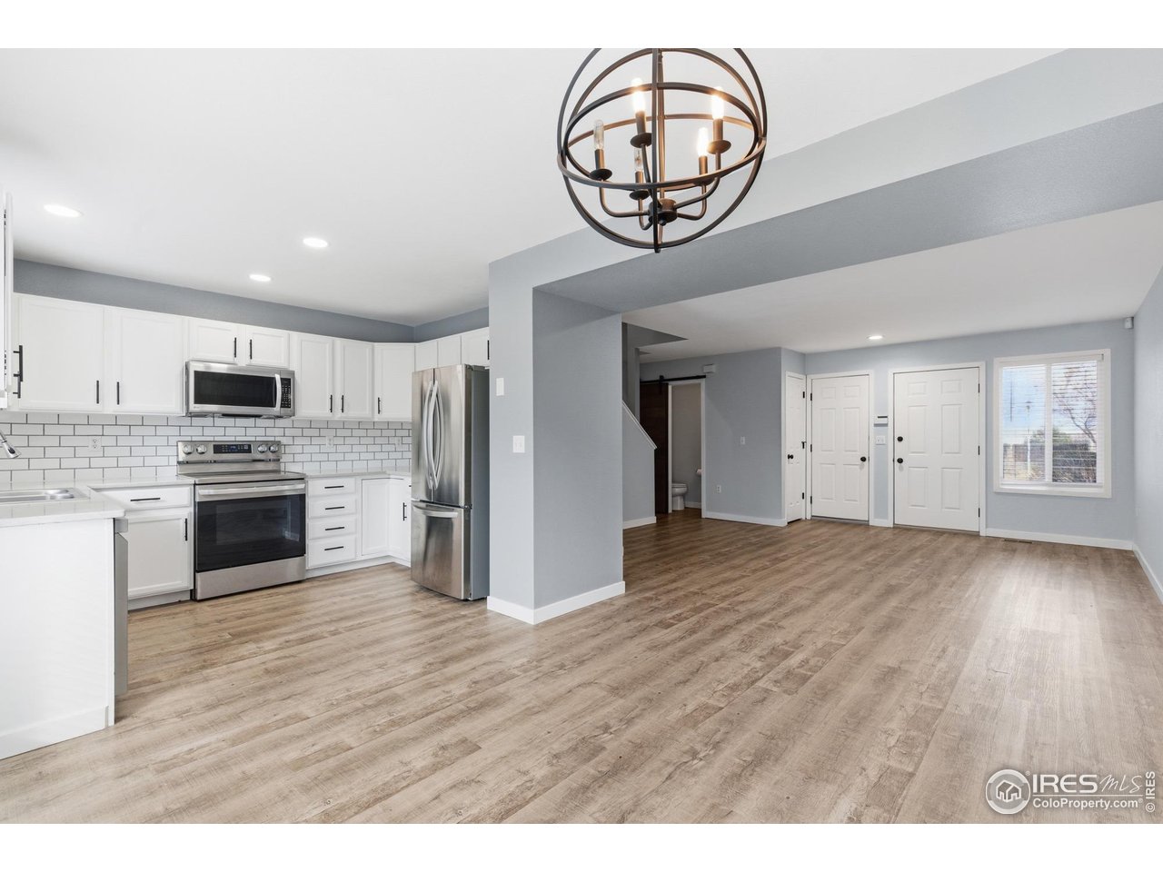 a view of kitchen with stainless steel appliances granite countertop a stove and a sink
