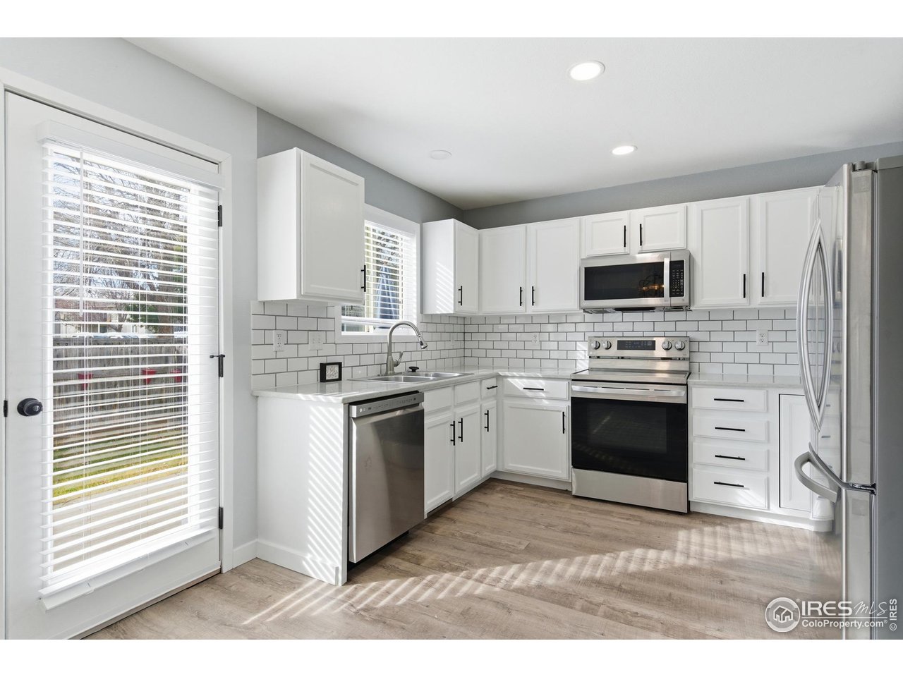 357 Albion Way, Unit 4 Fort Collins, CO 80526 - Photo 11 of 28 a kitchen with stainless steel appliances a stove a sink a microwave a refrigerator and cabinets
