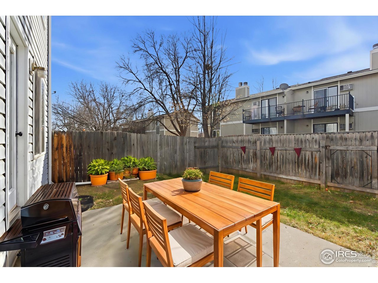 357 Albion Way, Unit 4 Fort Collins, CO 80526 - Photo 25 of 28 a view of a patio with table and chairs with wooden floor and fence
